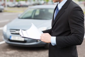 Man with Clipboard in Front of Car