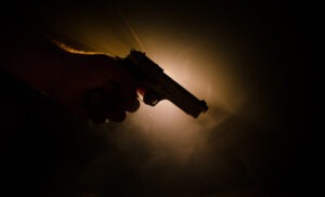 Male hand holding gun at a downward angle. Contact an Albuquerque accidental shooting lawyer for help with your case.
