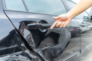 Man pointing at damaged vehicle after a hit and run