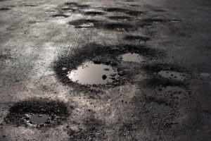 puddles of water in potholes on an Aurora road