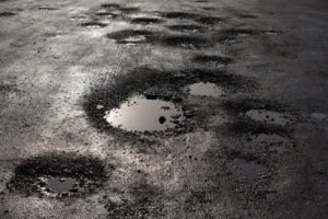 Puddles of water in potholes on an aurora road