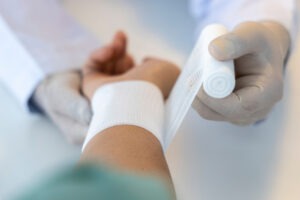 A doctor bandaging the wrist of a gunshot victim in need of an accidental shooting attorney in colorado springs