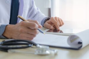 Doctor with clipboard, tablet and paperwork