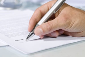 Close up,shot,of,hand,signing,a,document,with,a,silver