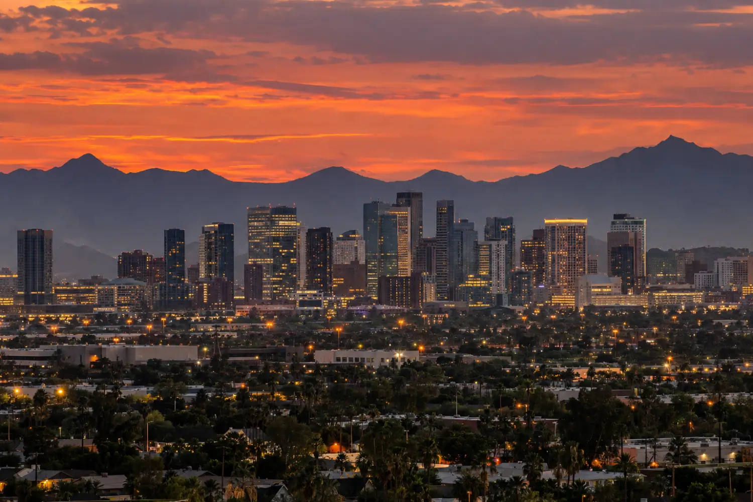 Downtown Phoenix skyline at dusk with the mountains behind it