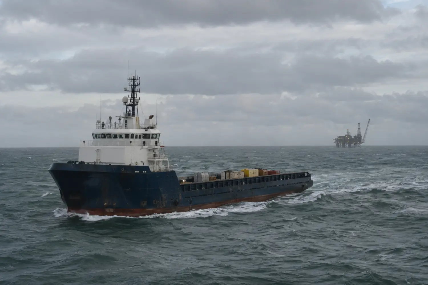 Offshore supply vessel under way on open water toward a distant production platform